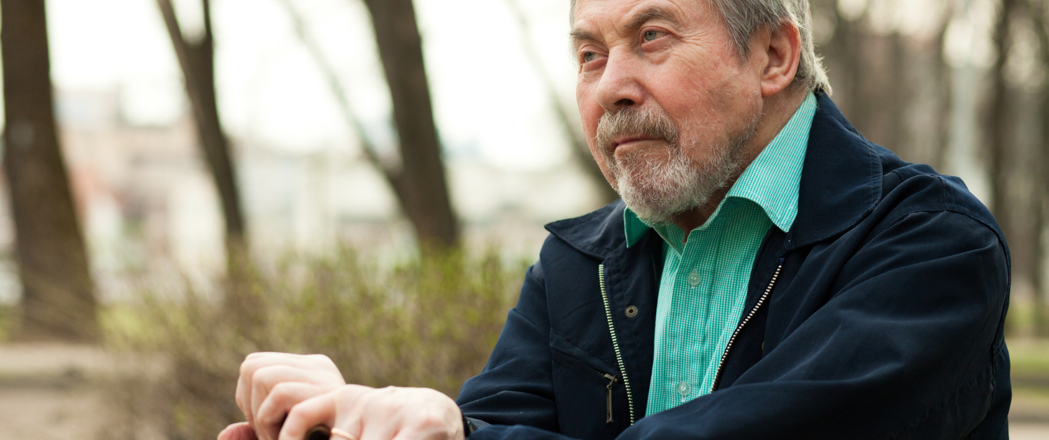 Parkinson_ Ein Mann sitzt nachdenklich auf einer Bank