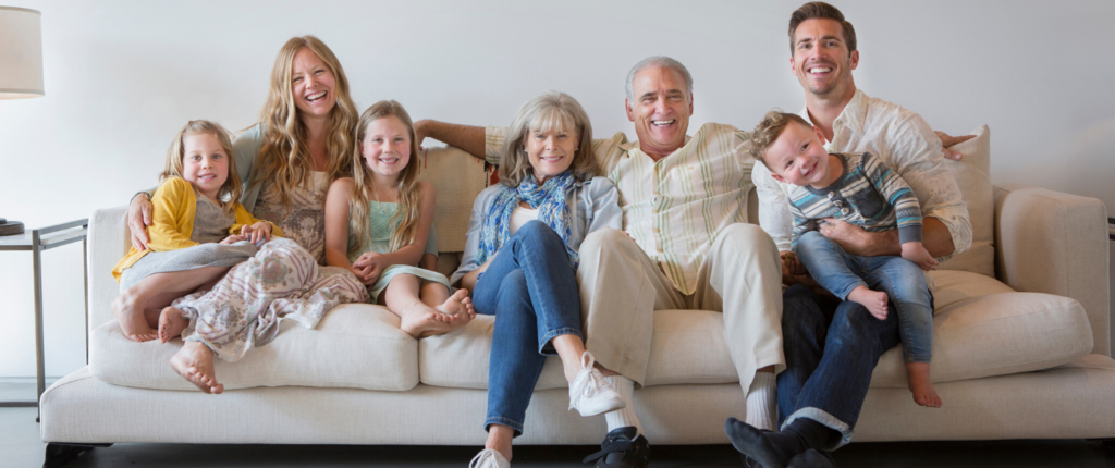 Drei Generationen einer Familie sitzen auf einem Sofa