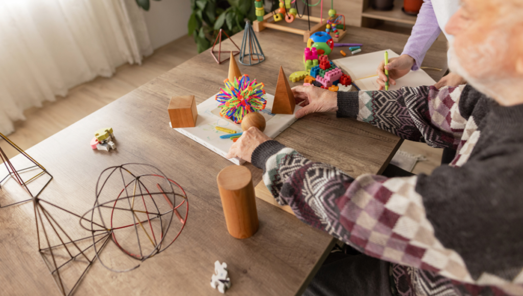 Tipps bei Sinneseinschränkungen: Älterer Mann übt mit verschiedenen gemoetrischen Formen und Gegenständen