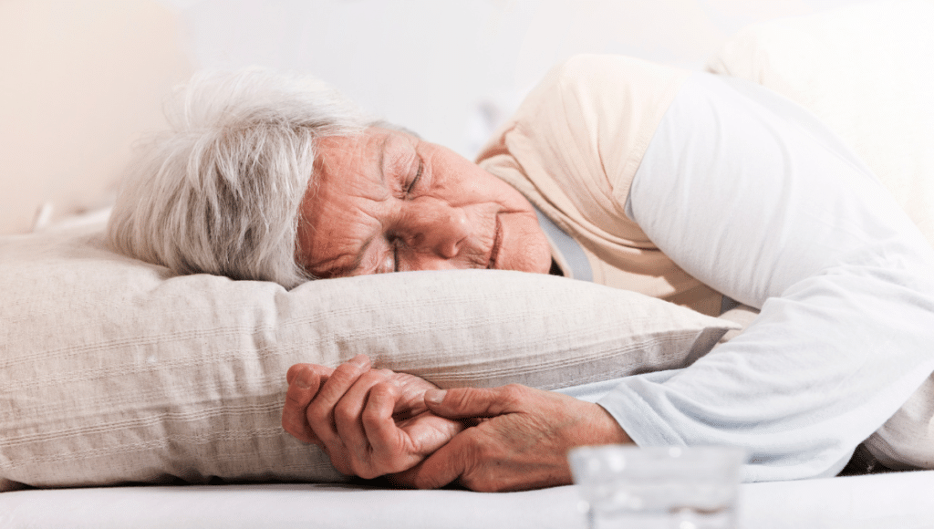 Erholsamer Schlaf: Eine alte Frau liegt mit dem Kopf auf dem Kissen in einem Bett.