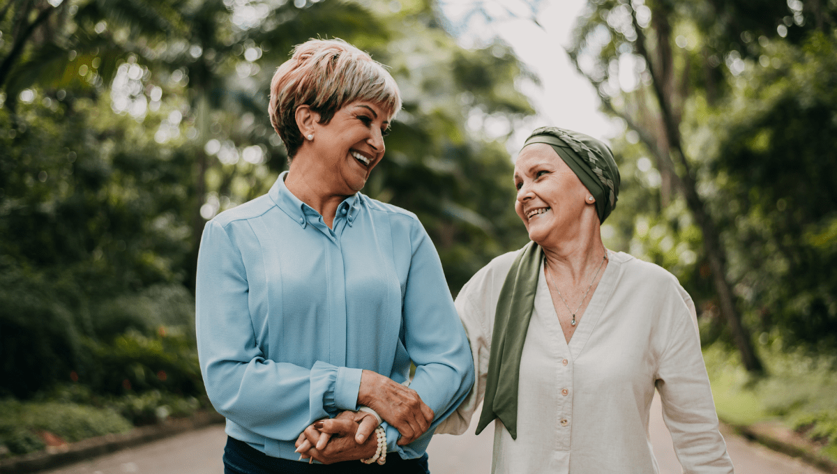 Eine Frau geht mit ihrer schwer kranken Freundin spazieren.