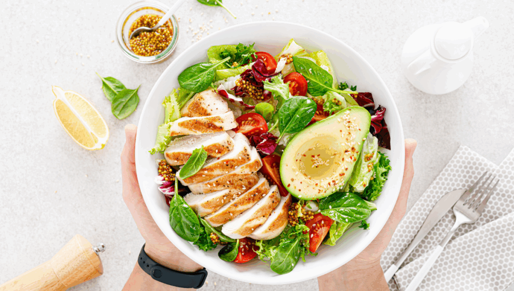 Frisches Essen im Sommer: Ein Teller mit Hähnchen, Salat und Avocado
