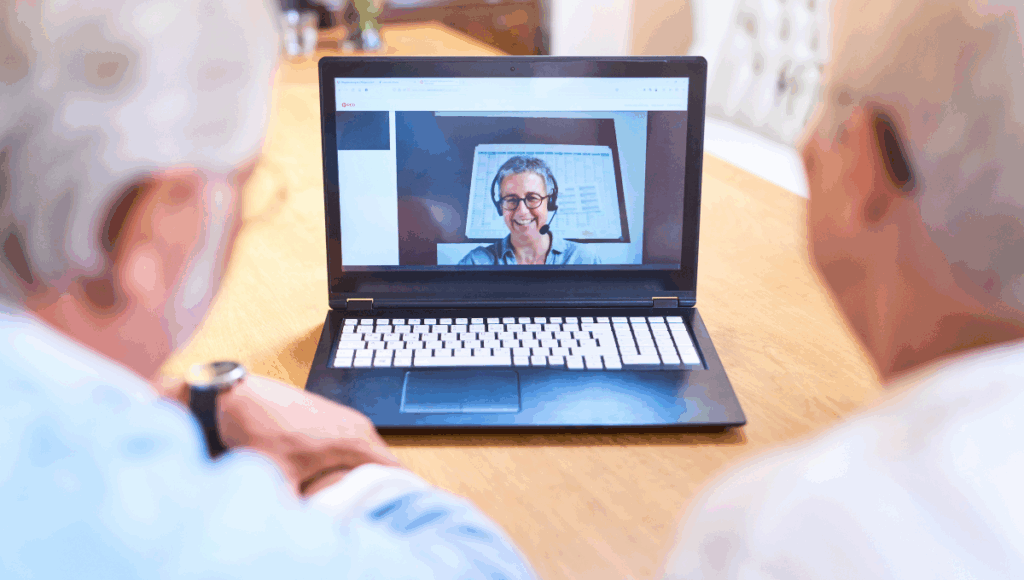 Zwei Personen erkundigen sich per Videocall bei einer Pflegeberaterin zu Beratungssterminen und Vermeidung von Pflegegeld-Kürzung.