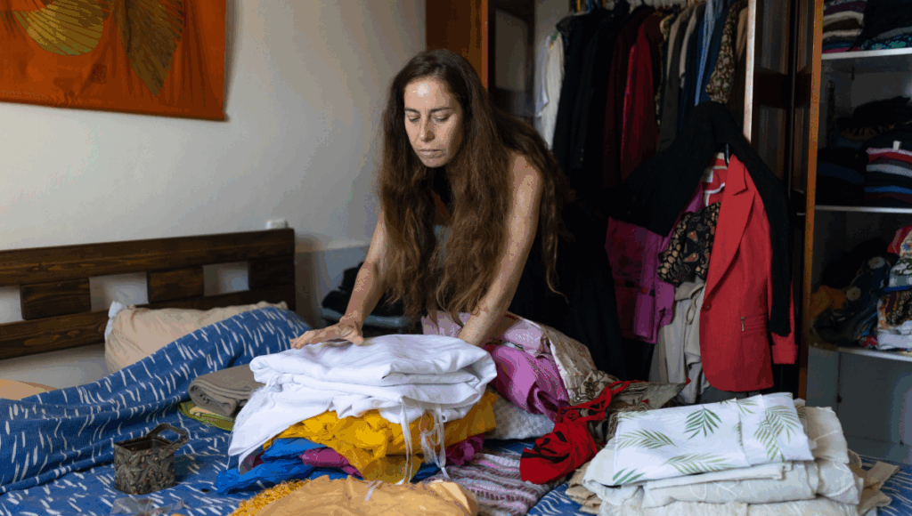 Eine Frau bei der Haushaltsauflösung im Schlafzimmer